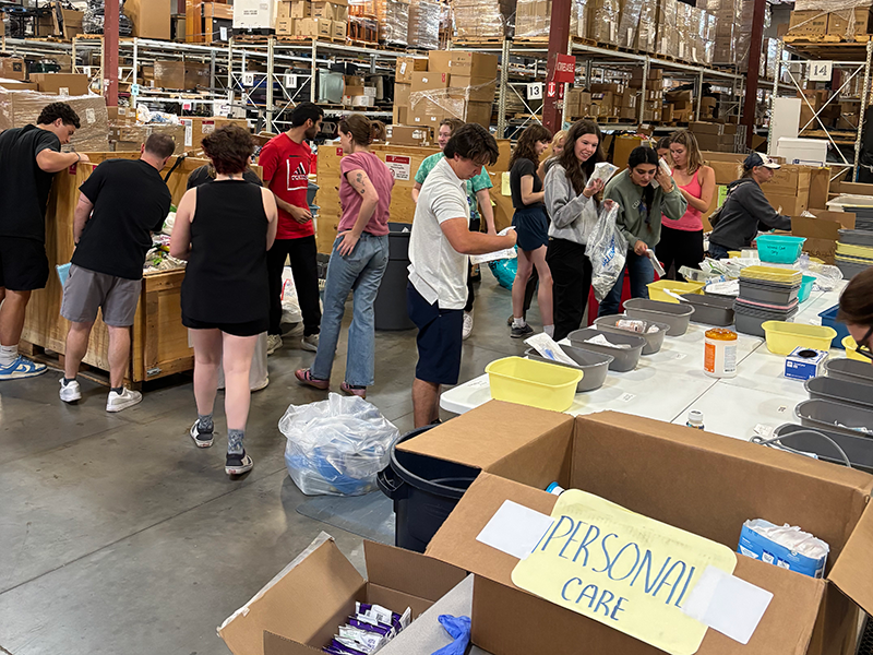 Inset_2025-Day-of-Service_Project-CURE.png students sort items in a warehouse as part of a Day of Service project