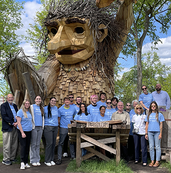 TWP_White-Earth_MN_May_2025_338x343.png group photo in front of wooden troll sculpture
