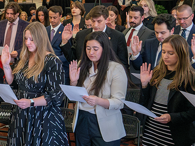 students raising hands taking oath