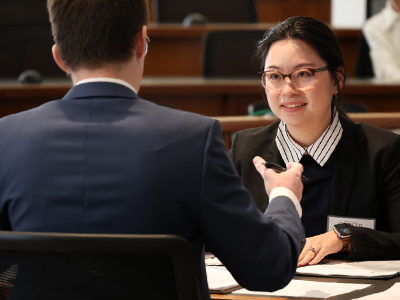 two individuals seated at table negotiating